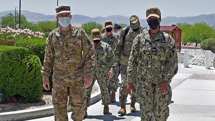 Military personnel wearing face masks walking