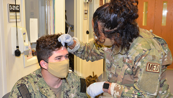 Military health personnel wearing face mask practicing using an EEG 