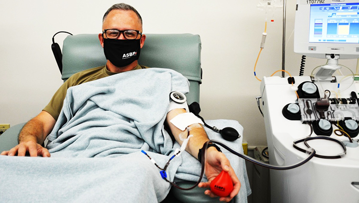 Man wearing mask in hospital chair giving blood