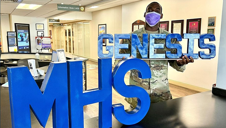 Image of A man holds an MHS GENESIS sign.