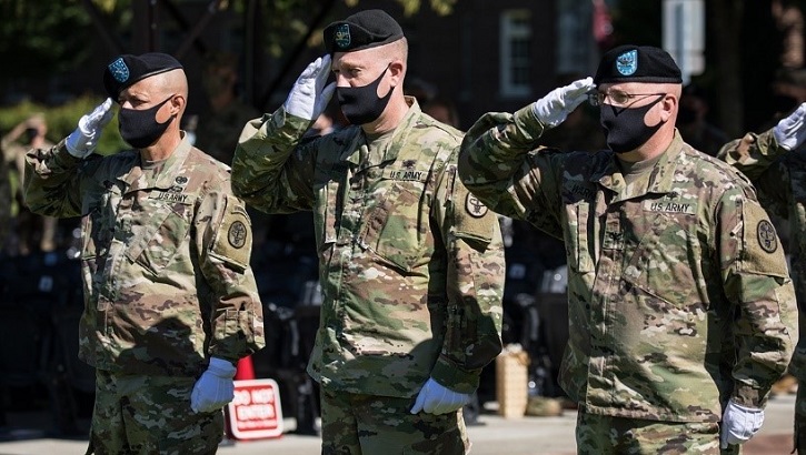 Three soldiers wearing masks and saluting
