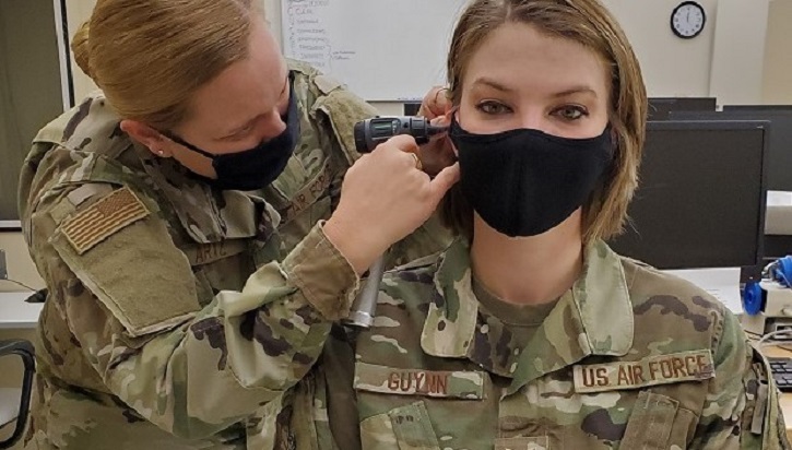 Image of Military doctor inspecting patient's ear. Click to open a larger version of the image.