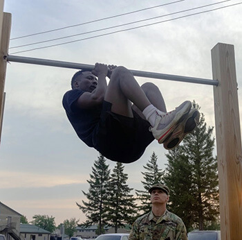 Military personnel doing a leg tuck