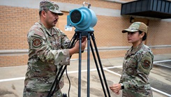 U.S. Air Force Tech. Sgt. Hector Mendez-Chavez, bioenvironmental engineering flight chief, Maxwell Medical Group, instructs Airman 1st Class Arely Ramirez-Munoz, bioenvironmental engineering technician, on how to set up and operate radiation detection equipment