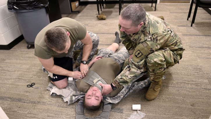 Image of Medical personnel training on how to treat a neck wound. Click to open a larger version of the image.