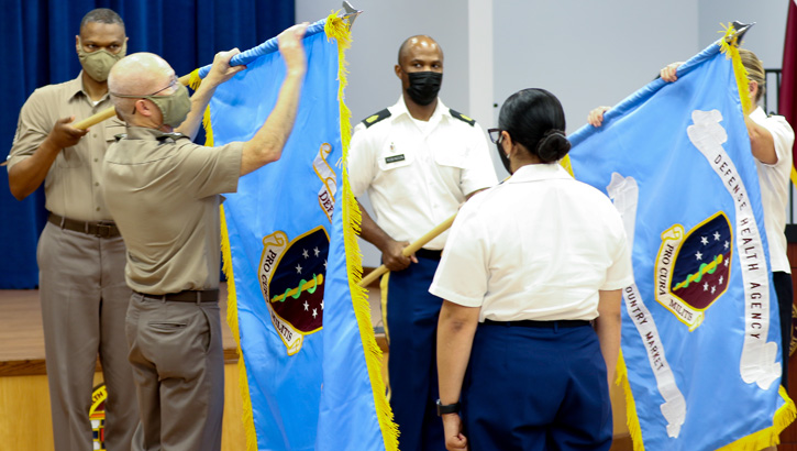 Image of Military personnel uncasing the DHA Low Country Market colors. Click to open a larger version of the image.