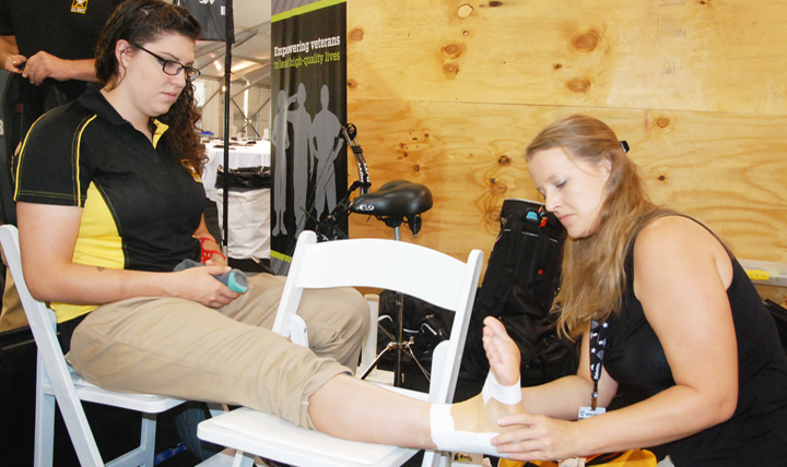 Jennifer Hoghe (right), a physical therapist with the Warrior Transition Battalion at Fort Stewart, Georgia, tapes up the ankle of Army Reserve Spc. Sydney Davis (left), a member of the Army’s archery team at the 2015 Warrior Games at Marine Corps Base Quantico, Virginia.