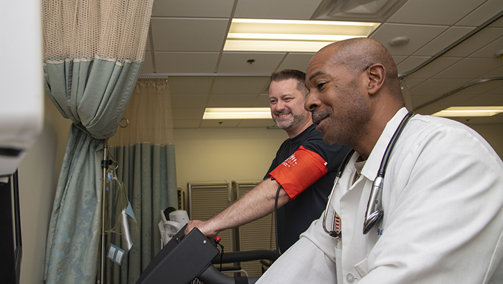U.S. Air Force Col. (Dr.) Travis Batts, medical director of the department of cardiology, provides feedback on a patient's performance