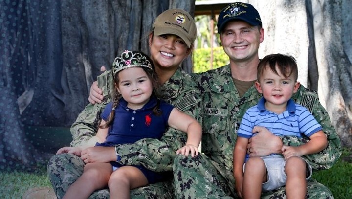 Image of Two children sit on two service members' laps.
