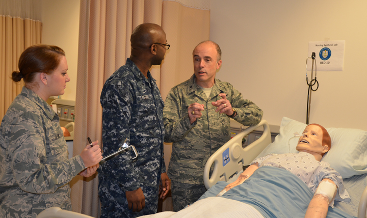 JOINT BASE SAN ANTONIO-FORT SAM HOUSTON, Texas - Brig. Gen.  Robert Miller, commandant of the Medical Education and Training Campus (METC), talks with Air Force Airman Amber Olson and Navy Seaman Joshua Raiford who are students in the Basic Medical Technician Corpsman Program. Olson and Raiford are learning basic nursing skills while conducting training in the program's  Nurse Synthesis lab.  (Photo by Lisa Braun)