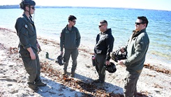 Naval Aircrewmen from the Naval Air Station (NAS) Patuxent River "SAR Dogs" unit prepare a simulated crash site on a beach prior to a rescue evolution. 