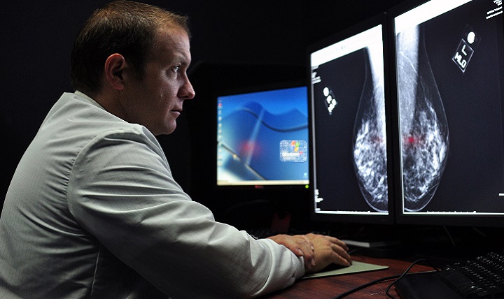 Navy Lt. Cmdr. Erik Ramey, reviews a patient’s x-ray as part of a routine screening mammogram. A mammogram can often detect breast cancer long before it can be felt and usually years before physical symptoms appear. If detected early, breast cancer treatment can be less invasive and more successful.  (DoD photo illustration)