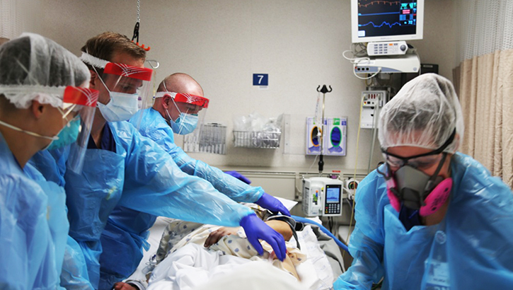 Image of medical personnel in a hospital room. Click to open a larger version of the image. Click to open a larger version of the image.