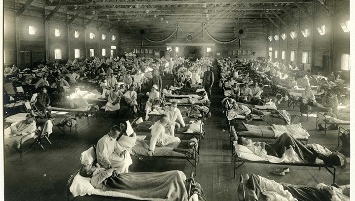 Image of Black and white image of hospital beds lined up in rows, occupied by sick people.