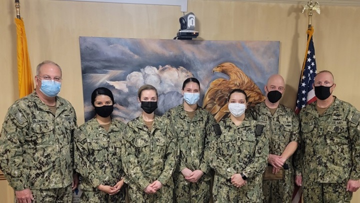 Image of Military personnel wearing face mask posing for a picture.