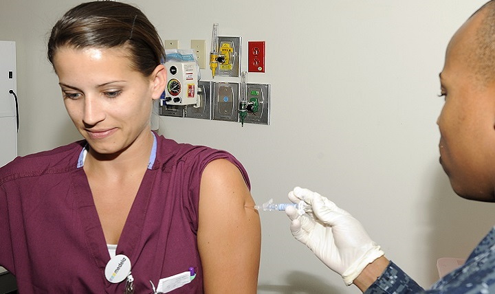 Navy Seaman Lavone Rhymtate, hospitalman, Naval Medical Center San Diego, administers the seasonal influenza vaccine to Labor and Delivery Registered Nurse, Navy Lt. j.g. Kelly McKenna. 