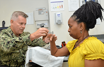 Military health personnel measuring the hand of a carpal tunnel patient