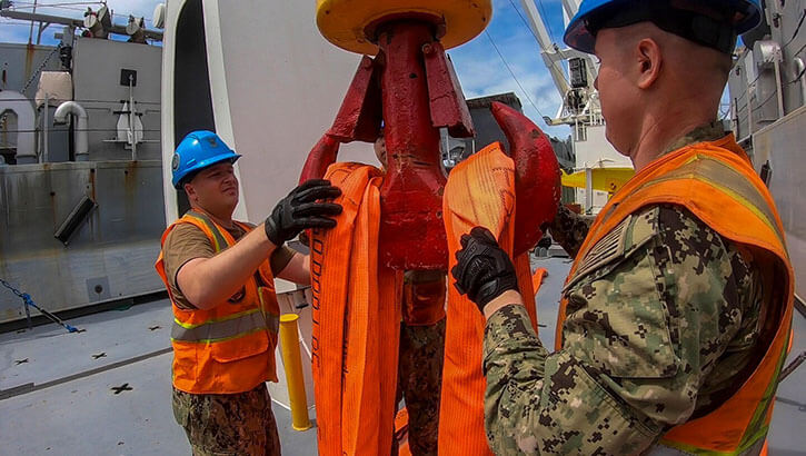 Military personnel working on a crane