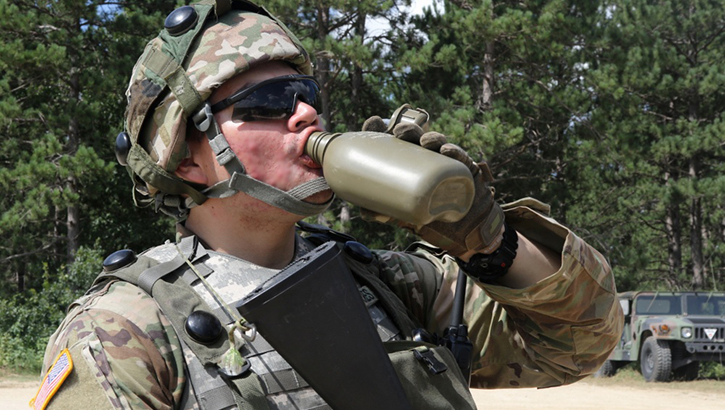 Image of A soldier takes a drink from his canteen. Click to open a larger version of the image.