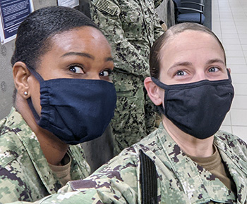 Two soldiers, wearing masks, taking a selfie