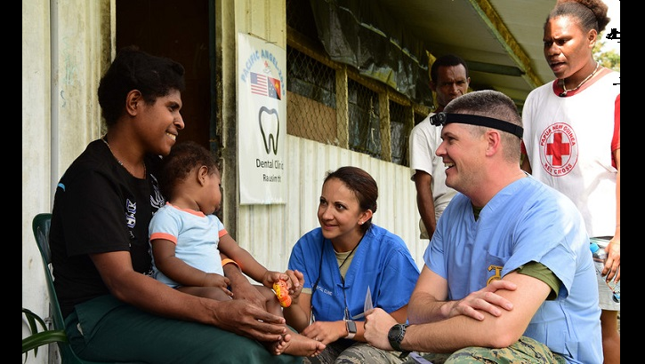 Navy Lt. Austin Stokes, (right), and Air Force Maj. Nicole Smith (center), both dentists, talk to a patient at the Pacific Angel 19-4 health outreach site in Lae, Papua New Guinea. The health outreach site is comprised of five clinics including primary care, optometry, dental, physical therapy and pharmacy. (U.S. Air Force photo by Staff Sgt. Jerilyn Quintanilla)