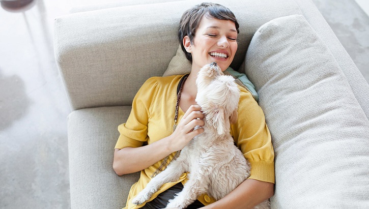 Woman laying on couch with her dog