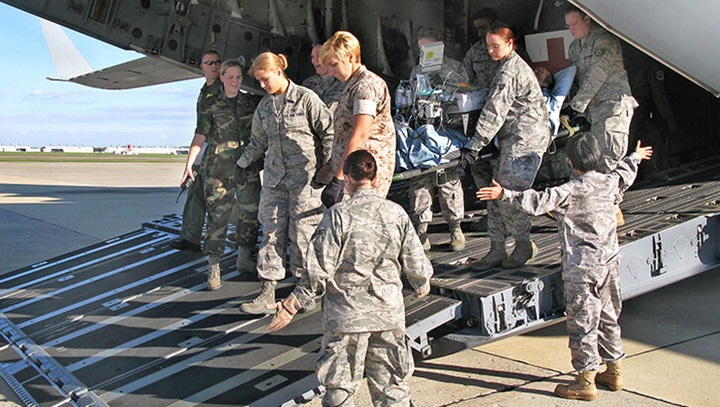 Image of Service members transporting a severely wounded soldier.