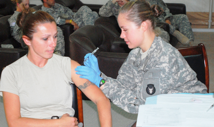 Specalist Albana Luli (left), a transport management specialist with the 159th Support Operations Company, receives her H1N1 shot from Pfc. Amber Hale, a medic with the 34th Infantry Division. Reserve and guard units get RHRP services through regularly scheduled readiness group events or on an as-needed basis. Those service members preparing to deploy are examined, especially for dental care, and their vaccinations are updated. (U.S. Army photo by Sgt. Francis Horton.)