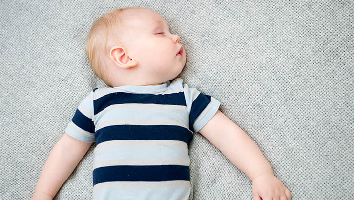 Image of baby boy asleep on his back in a crib. Click to open a larger version of the image.
