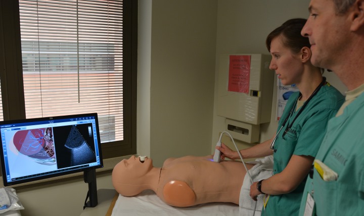 San Antonio Military Medical Center Department of Emergency Medicine Air Force Capt. Erin Hanlin (left) and Dr. Jeremiah Johnson practice using an Ultrasound 3-D Simulator during the SIM Center open house. (Photo by Robert Shields, BAMC Public Affairs)