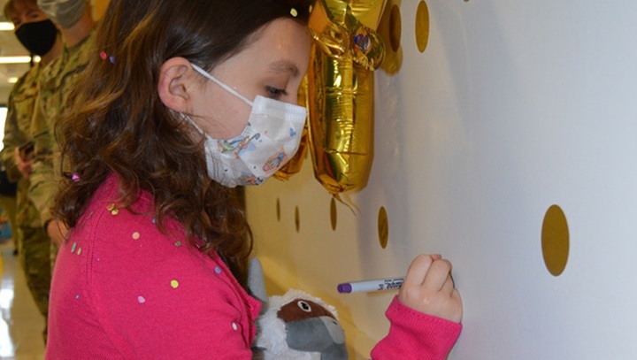 Image of Sailor Parker writing her name on a wall sticker .