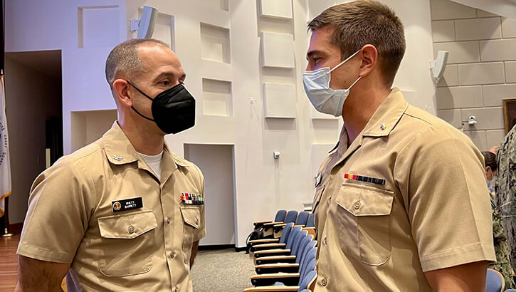 Image of Two Naval medical officers in masks discuss career opportunities in San Diego.
