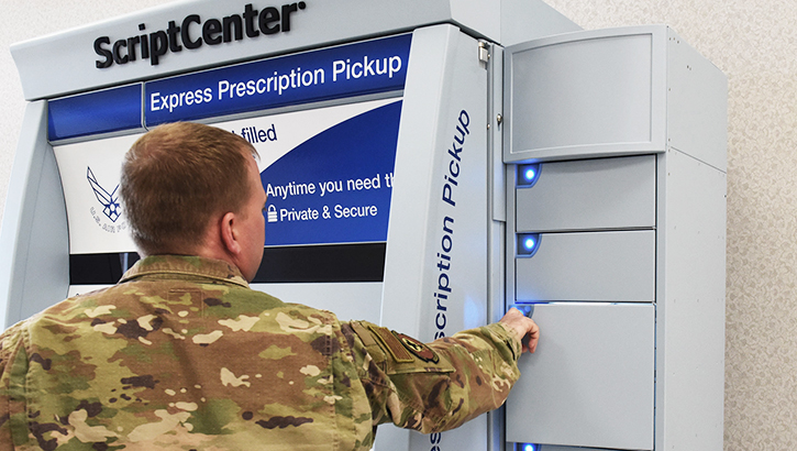 Image of A pharmacy technician opens a locker holding prescription medication. Click to open a larger version of the image.
