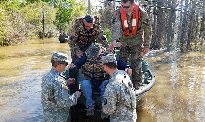Louisiana National Guard Soldiers with the 2225th Multi-Role Bridge Company, 205th Engineer Battalion, help a man out of the bridge erection boat they used to check on residents affected by flooding in Ponchatoula, Louisiana. (U.S. Army photo by 1st Lt. Rebekah Malone)
