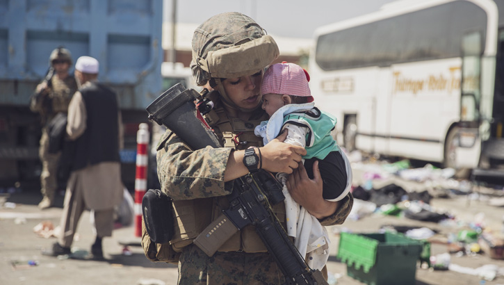 Image of A U.S. Marine carries a baby as the family processes through the Evacuation Control Center during an evacuation at Hamid Karzai International Airport, Kabul, Afghanistan, Aug. 28. (U.S. Marine Corps photo by Staff Sgt. Victor Mancilla). Click to open a larger version of the image.