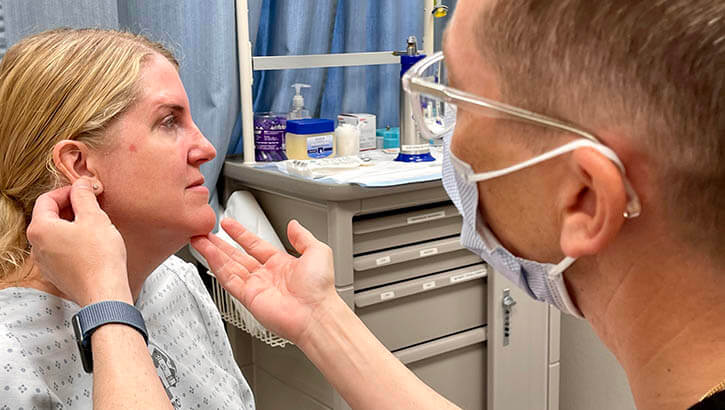 U.S. Air Force Maj. Shannon Buck, a dermatologist at Landstuhl Regional Medical Center (LRMC), provides a skin cancer screening for military spouse Judy Srey on May 3, 2022.