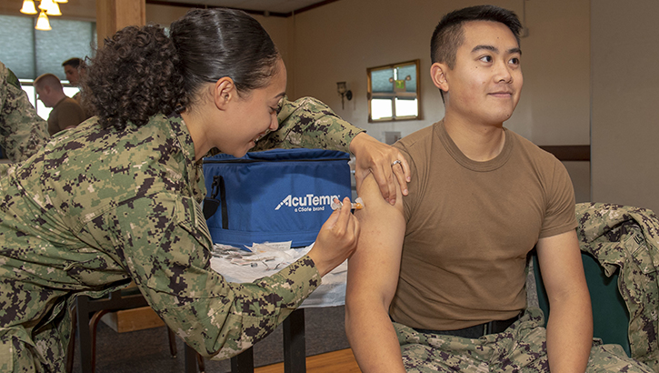 Hospital Corpsman administers a flu shot to a navy officer.