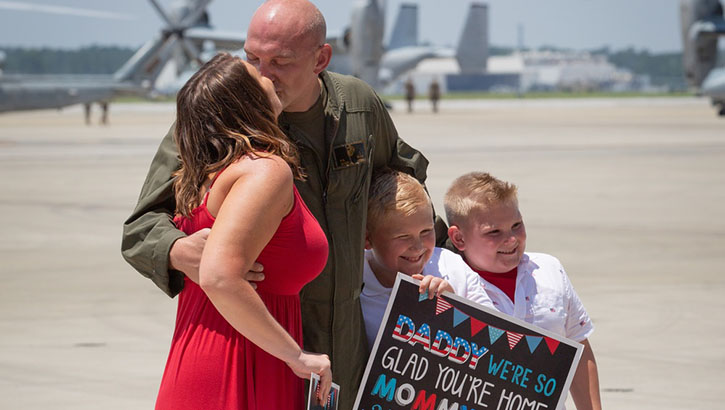 An Airman is greeted by his family after a deployment.