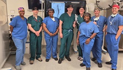 A vascular surgery team poses in an operating room at Walter Reed National Military Medical Center after completing a thoracoabdominal branch endoprosthesis (TAMBE) procedure.