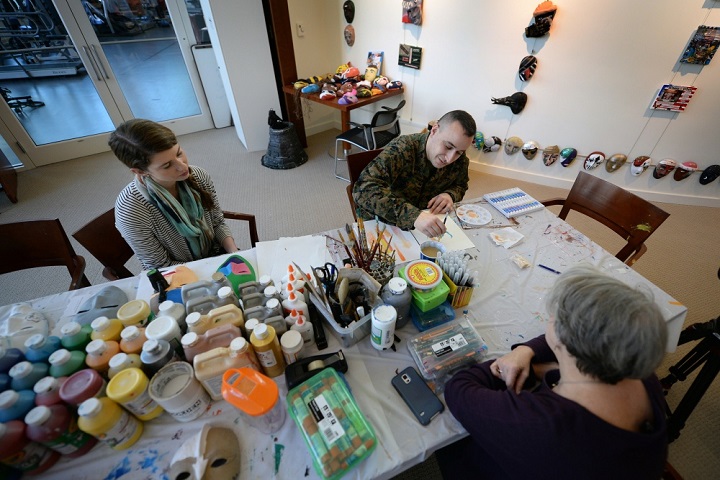 Marine Corps Staff Sgt. Anthony Mannino performs Art Therapy as part of his Traumatic Brain Injury (TBI) treatment and recovery. Art Therapy Interns, Adrienne Stamper (left) and Nancy Parfitt instruct and work with Mannino as he receives his art therapy. The therapy is conducted at the National Intrepid Center of Excellence, Walter Reed National Military Medical Center located in Bethesda, Maryland. (Department of Defense photo by Marvin Lynchard)