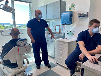 Three military personnel in a dental office