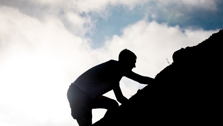 Image of Silhouette of man climbing a hill.