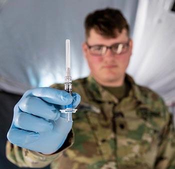 Military personnel holding the flu vaccine