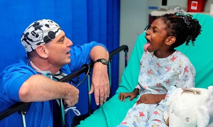 U.S. Navy Cmdr. William Cavill examines a child before her surgery aboard the hospital ship USNS Comfort in Roseau, Dominica. The medical care is part of Continuing Promise, a civil-military effort that includes humanitarian-civil assistance, medical, dental and veterinary support. Cavill is an anesthesiologist assigned to Naval Hospital Pensacola, Florida. (U.S. Army photo by Spc. Lance Hartung)