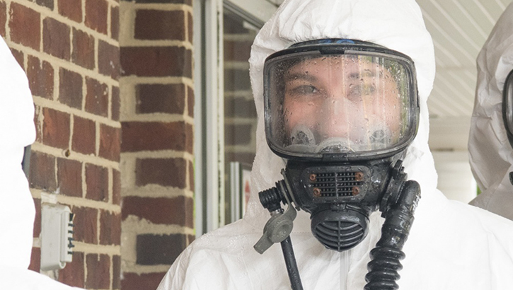 Image of Woman in white chemical suit. Click to open a larger version of the image.