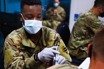 Military personnel administering the COVID-19 vaccine