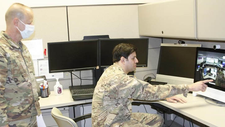 Military personnel looking at a computer