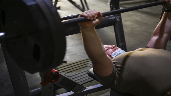 Image of Military personnel performing a bench press.