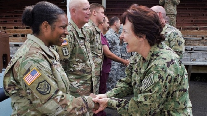 Image of Navy Rear Adm. Mary Riggs greets Army Maj. Angela Hinkson.