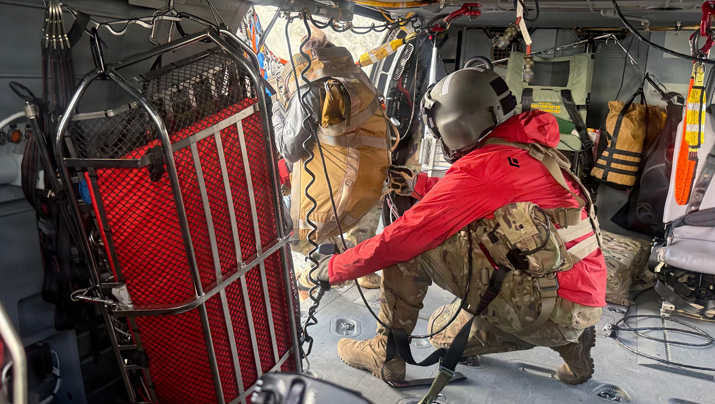 An HH-60M Black Hawk crew chief assigned to the 211th General Support Aviation Battalion, 2nd Aviation Regiment, hoists a hiker stranded on Matanuska Peak in Alaska's Chugach Mountains